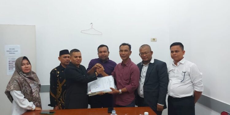 Ketua Pansel Hamdani, SE.,MSM (kiri) menyerahkan berkas 15 nama calon Panwaslih Kabupaten Bireuen kepada Ketua DPRK Rusyidi Mukhtar, S.Sos (kanan), disaksikan Ketua Komisi I M. Nasir (tengah) di Gedung DPRK Bireuen pada Minggu, (12/05/2024) kemarin. (Foto/Ist)